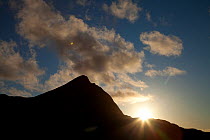Sun on skyline of Ben Mor Coigach, Ben Mor Coigach Scottish Wildlife Trust reserve, Coigach, Scotland, UK, March 2012,