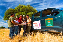 People working for Rewilding Europe project next to vehicle in Campanarios de Azaba Biological Reserve, a rewilding Europe Area, Salamanca, Castilla y Leon, Spain, March 2012