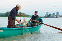 Fishermen pulling in net catch on river, Sfinthu Gheorghe, Danube delta rewilding area, Romania