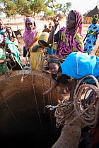 Gula women drawing water from well, they are Magreb Arab descendants originally from Sudan. Precious water is drawn from a communal well each day by women and girls in the village of Bon,  Zakouma Nat...