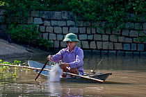 Man in tiny fishing boat with net, Phan Thiet, Vietnam.