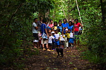 Group of local school children watching  Celebes / Black crested macaque (Macaca nigra)  Tangkoko National Park, Sulawesi, Indonesia, May 2011