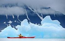 Kayaking past icebergs in Svalbard, Norway, July 2011. Model released.