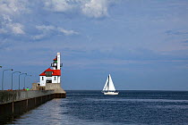 Yacht passing lighthouse at the entrance to the Ship Canal in Duluth, Lake Superior, Minnesota, USA, August 2011