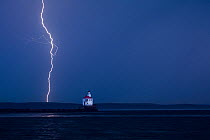 Lightning storm during sunrise at Wisconsin Point Lighthouse on Lake Superior near the town of Superior. Wisconsin, USA, August 2011