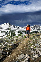 Man hiking along the Death Canyon Shelf on the Teton Crest Trail in Grand Teton National Park. Wyoming, USA, July 2011