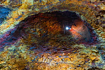 Inside the Thrihnukagigur volcano with torch light from a tour at the end of a tunnel. This dormant volcano is now used for tours, Iceland, June 2012