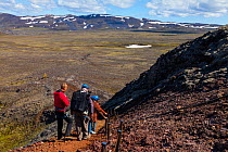 Tourists walking away from the Thrihnukagigur volcano, a dormant volcano now used for tours inside. Iceland, Europe, June 2012