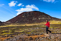 Man walking from the Thrihnukagigur volcano, a dormant volcano now used for tours inside the volcano. Iceland, Europe, June 2012