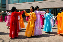 Women in traditional dress dancing during street celebrations on the 100th anniversary of the birth of President Kim IL Sung, Pyongyang, Democratic Peoples' Republic of Korea (DPRK), North Korea, Apri...