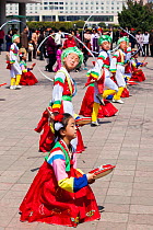 Children in traditional dress dancing during street celebrations on the 100th anniversary of the birth of President Kim IL Sung, Pyongyang, Democratic Peoples' Republic of Korea (DPRK), North Korea, A...