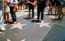 Tourists looking at stars on Walk of Fame, Hollywood Boulevard, Los Angeles, California, USA
