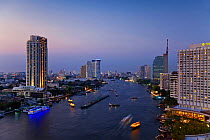 Chao Phraya river and the modern Bangkok skyline at dusk, Bangrak district, Bangkok, Thailand, 2010