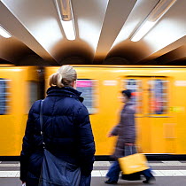 Moving train pulling into the station with people waiting, modern subway station, Berlin, Germany, 2009. No release available.