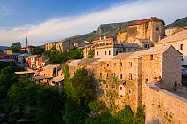 View of the Old Town and cobbled street lined with colourful houses known as Kujundziluk, one of the oldest streets in Mostar leading to the Old Bridge, Mostar, Herzegovina, Bosnia and Herzegovina, Ba...