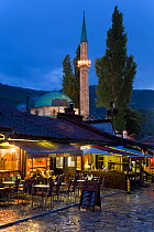 Restaurants lining 'Pigeon Square' in front of Bascarsija Mosque, illuminated at dusk, Old Town, Bascarsija district, Sarajevo, Bosnia and Herzegovina, Balkans 2007