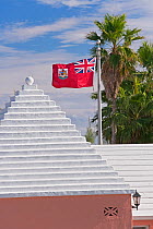 Traditional white stone roofs on houses, with national flag flying above, Bermuda 2009