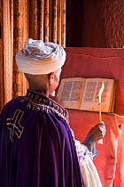 Priest holding a candle and reading the 900 year old Holy Book of Gabriel in Bet Gabriel-Rufael, one of Lalibela's famous rock-hewn churches, Lalibela ranks among one of the world's greatest Christian...
