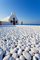 White pebbles and Church overlooking Aegean Sea in the village of Oia (La), Santorini (Thira), Cyclades Islands, Greece, 2010