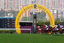 Horses race past large scoreboard during race at Happy Valley racecourse, Wan Chai, Hong Kong, China 2007