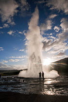 People standing by Strokkur (the Churn) geyser which spouts up to 35 meters erupting every 10 minutes, Golden Circle, Iceland 2006