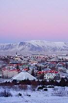 Elevated view over the Churches and cityscape of Reykjavik with a backdrop of snow capped mountains, Iceland 2006