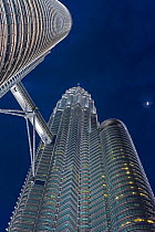 Looking up at Petronas Towers at night - 88 storey steel clad twin towers with a height of 451.9 metres - the iconic symbol of KLCC (Kuala Lumpar City Centre) urban development complex, Selangor, Mala...