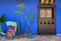 Detail of Trishaws lined up against a blue painted wall in Chinatown district, Georgetown, Penang (Pulau Pipang) Malaysia 2008