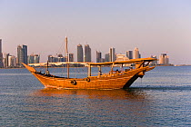 Traditional boat infront of city skyline, Doha Bay looking towards the Business and Financial district of the West Bay area, Doha, Qatar, Arabian Peninsula 2007