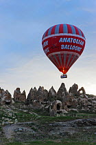 Hot Air Balloon with the Worlds largest passenger basket just above the tufa rock formations near Goreme, Cappadocia, Anatolia, Turkey, 2008