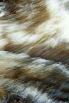 River in full spate  flowing fast in winter, water close up,  Gannochy winter, Scotland, February.