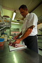 Diver and Chef Hagen preparing lionfish at Cactus Blue restaurant, Kralendijk, Bonaire, Caribbean, February 2012