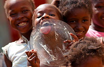 A hungry girl licking plate clean, at a street market vendor in the city of Sao Tomeon the Atlantic Ocean islands of Sao Tome & Principe, February 2009