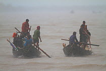 Fishermen in boats on river during monsoon rain, Sundarbans, Bangladesh, September 2011. No release available.