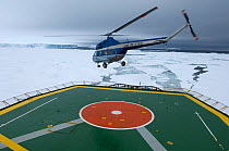 Tourist helicopter taking off from heli-deck of ice-breaker, on route to Snow Hill Island Emperor Penguin colony, Weddell Sea, Antarctica, November 2006