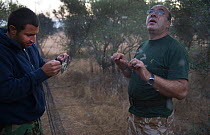 Officers from the British Sovereign Base Area Police anti trapping unit at Dekeleia extracting a Blackcap (Sylvia atricapilla) from an illegal trappers mist nest in Cyprus, September 2011