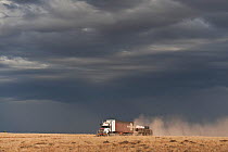 Bad weather looming ahead along the Strzelecki Track with a road train passing, South Australia