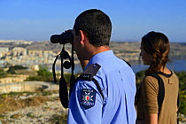 Fiona Burrows from BirdLife Malta and ALE (Administrative Law Enforcement) Officer monitoring illegal Turtle Dove (Streptopelia turtur) trappers on hillside, during BirdLife Malta Spring Watch Camp,...