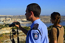 Fiona Burrows from BirdLife Malta and ALE (Administrative Law Enforcement) Officer monitoring illegal Turtle Dove (Streptopelia turtur) trappers on hillside, during BirdLife Malta Spring Watch Camp,...
