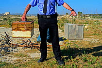 ALE (Administrative Law Enforcement) police with confiscated turtle doves (Streptopelia turtur) and equipment from dove trapping area, during BirdLife Malta Springwatch Camp, Malta, April 2013. No rel...
