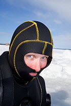 Scuba diver with special head hood for cold water diving, Arctic circle Dive Center, White Sea, Karelia, Northern Russia, April 2009. No release available.