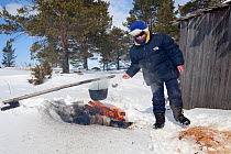 Cooking over open fire on the snow, Arctic circle Dive Center, White Sea, Karelia, Northern Russia, April 2009