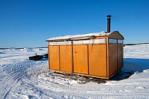 Wooden cabins on sledges provide shelter for changing and drying of equipment, Arctic circle Dive Center, White Sea, Karelia, Northern Russia, March 2010