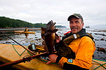 Fishing from a kayak in the Straits of Juan De Fuca near Sail and Seal Rocks. Washington, USA, August. Model released