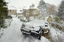 Car that has slid off driveway after losing traction on deep snow, Wiltshire, UK, January 2013