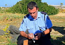 ALE (Administrative Law Enforcement) Police with confiscated Turtle Dove (Streptopelia turtur) and equipment from dove trapping area raided, during Bird Life Malta Springwatch Camp, Malta, April 2013