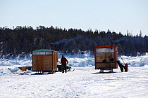 Wooden cabins on sledges provide shelter for changing and drying of equipment, Arctic circle Dive Center, White Sea, Karelia, northern Russia March 2010
