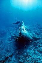 Diver on the wreck of the US Submarine tender USS Macaw, sunk in the World War II due to a navigation error, Midway atoll, Pacific Ocean. Model released.