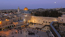 Timelapse from day to night of people praying at the Wailing Wall, with the Dome of the Rock illuminated in the background, Temple Mount, Jerusalem, Israel, 2011.