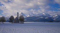 Timelapse of clouds moving above and around St Coleman's Church, with snowcapped mountain in background, Schwangau, Germany, 2011.